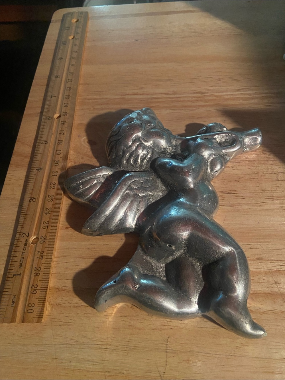 silver-toned metal cherub or angel wall decoration depicting a winged baby angel